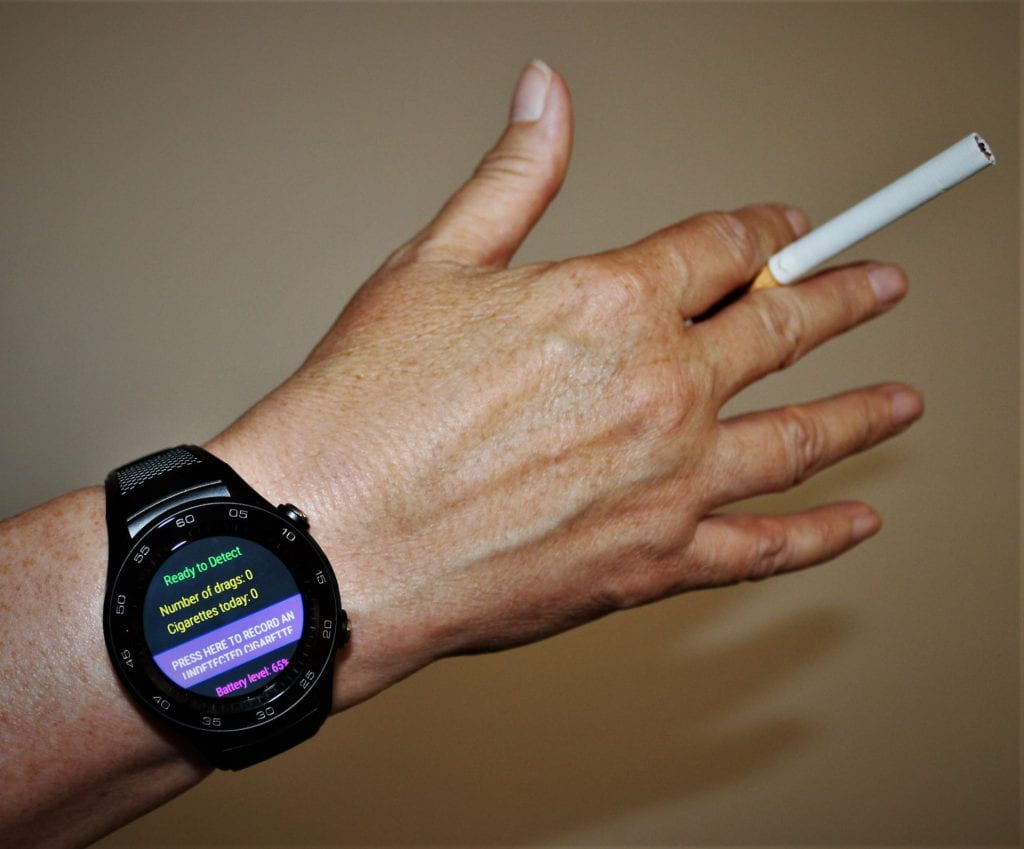 Hand and wrist wearing stopWatch and holding a cigarette